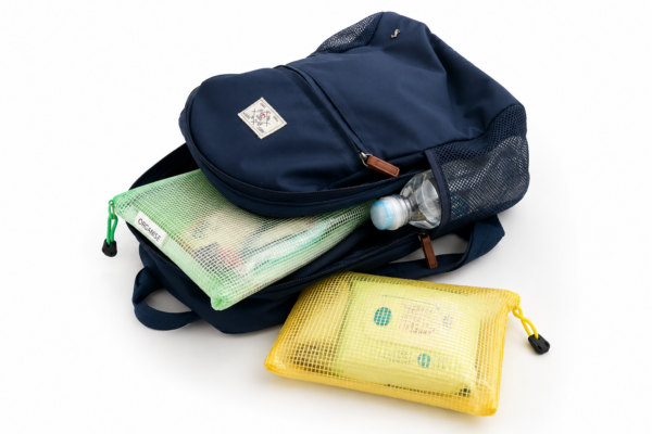 Family travel backpack organised with colour-coded mesh pouches and a water bottle for flights and holidays with children