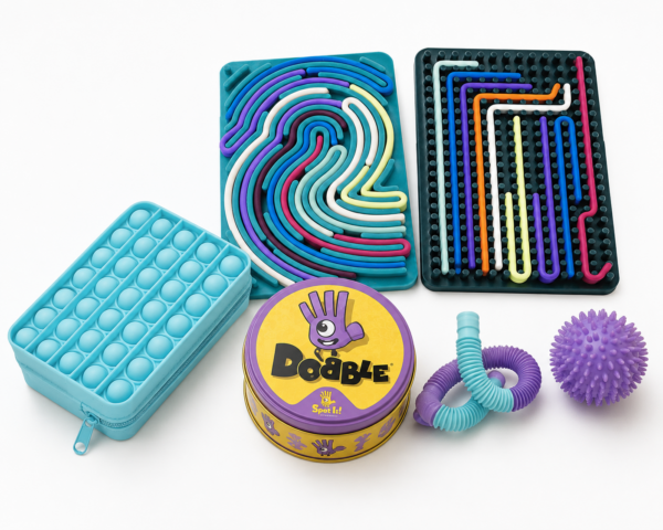 Travel-friendly sensory boards, Dobble card game and fidget toys arranged on a white background for toddlers and young children during flights and holidays.