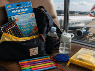 Toddler travel backpack with Water Wow books, sticker books, sensory toys and travel activities at an airport before a flight.